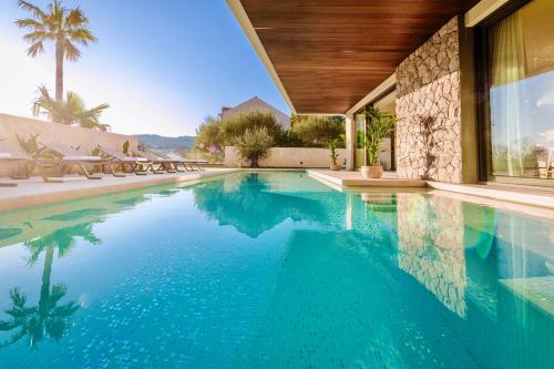 a swimming pool with blue water in a house at Villa W by Villas & SPA Dubrovnik in Mokošica
