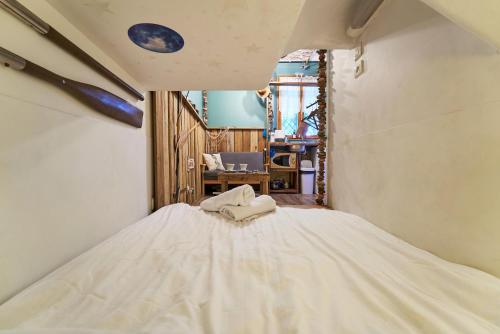 Cette chambre comprend un grand lit blanc. dans l'établissement La Cabine du Capitaine - Escale iodé & plage à 100m, à Toulon