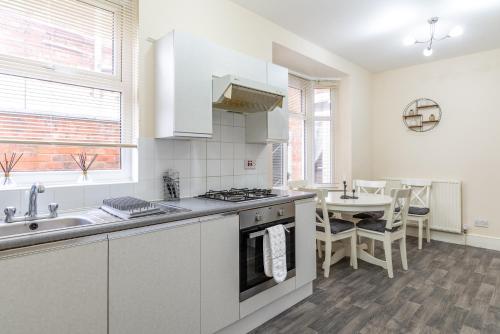 a kitchen with a sink and a stove top oven at Beacon House in Leicester