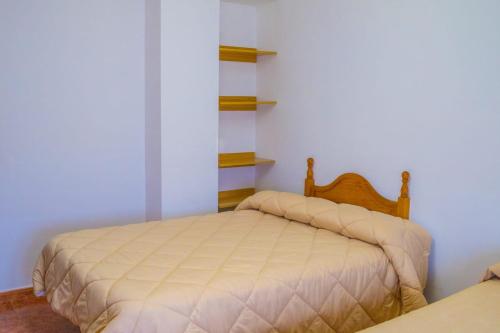 1 dormitorio con 1 cama y estanterías en la pared en Apartamento Oran 2, en Castril