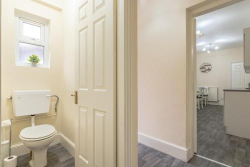 a white bathroom with a toilet and a window at Beacon House in Leicester