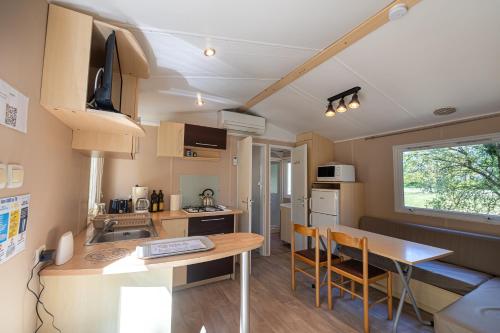 - une petite cuisine et un coin repas dans l'établissement Mobil Home climatisé, 2 ch, 5 pers, Wifi 30 mn du grand parc d'attraction Puy duFou, à La Boissière-de-Montaigu