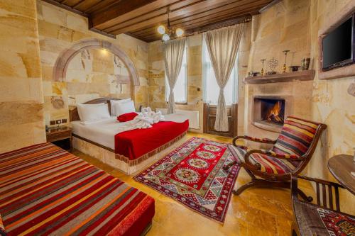 a bedroom with a bed and a fireplace at Akuzun Stone Hotel in Ürgüp
