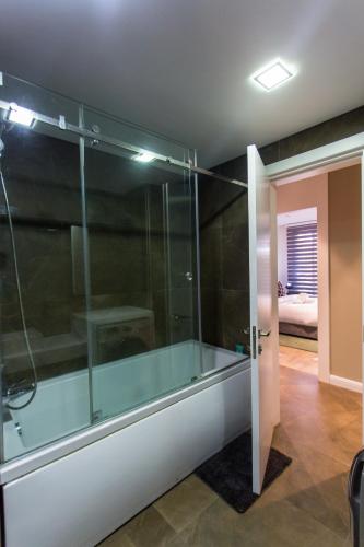 a glass shower in a room with a bedroom at Accra Luxury Apartments @ Pearl in Accra