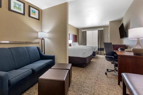 a hotel room with a couch and a bed at Comfort Suites Plano - Dallas North in Plano