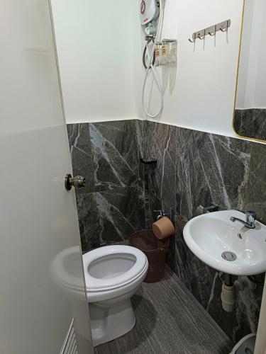 a bathroom with a toilet and a sink at MilVir Tourist INN in El Nido
