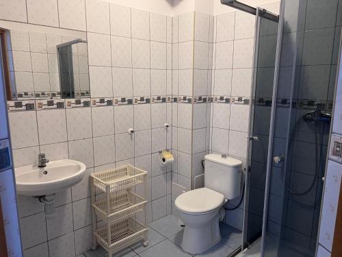 a bathroom with a toilet and a sink and a shower at Pokoje Alina, 500m do morza ze śniadaniem in Grzybowo