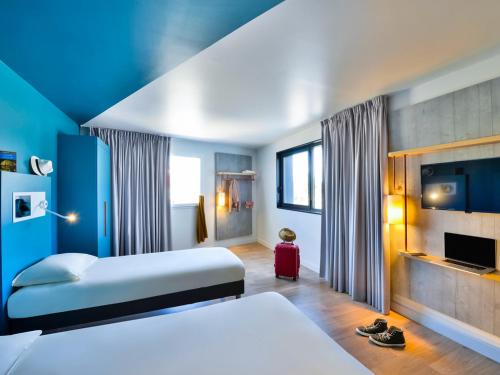 a hotel room with a bed and a fireplace at ibis Budget Mâcon Crêches in Chaintré