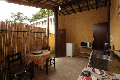 a room with a table and a kitchen with a sink at Apoena Chales da Ilha in São Francisco Xavier