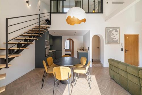 un salon avec une table et des chaises et un escalier dans l'établissement REF 1993 - Cannes Center Renovated Apartment, à Cannes