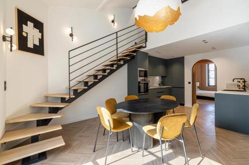 une salle à manger avec une table et des chaises et un escalier dans l'établissement REF 1993 - Cannes Center Renovated Apartment, à Cannes