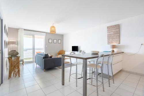 une cuisine et un salon avec une table et des chaises dans l'établissement Rêve Bleu, 2 p, vue mer panoramique, à Penmarcʼh