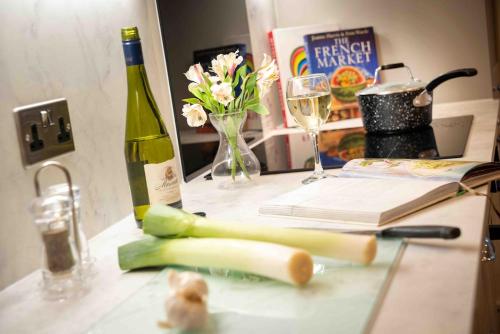 a table with a bottle of wine and a book at Luxury Pet Friendly 3 Bedroom Home with Copper Bath in Bowness-on-Windermere