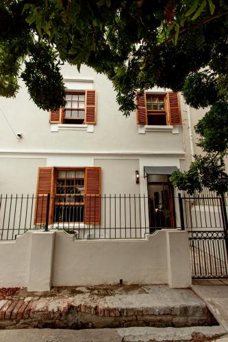 a white house with brown windows and a fence at Double Story at 55 in Graaff-Reinet