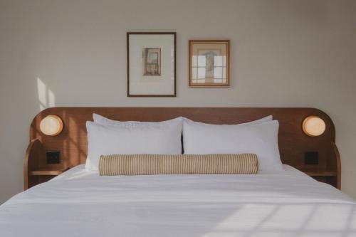 a bed with white sheets and two pictures on the wall at The Belvedere Hotel - Kingston in Kingston