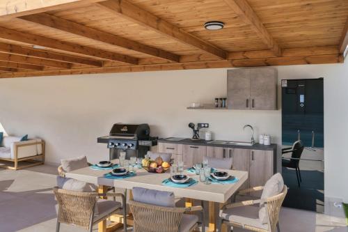 a kitchen with a table and chairs in a room at Elysian Villas - With 2 Private Pools in Roumelí