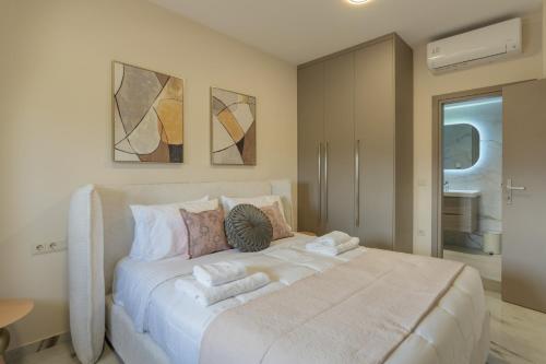 a bedroom with a large white bed with towels on it at Elysian Villas - With 2 Private Pools in Roumelí