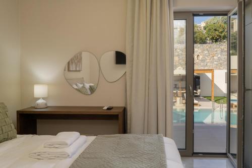 a bedroom with a bed and a mirror on the wall at Elysian Villas - With 2 Private Pools in Roumelí