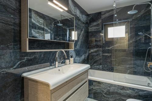 a bathroom with a sink and a shower and a tub at Elysian Villas - With 2 Private Pools in Roumelí