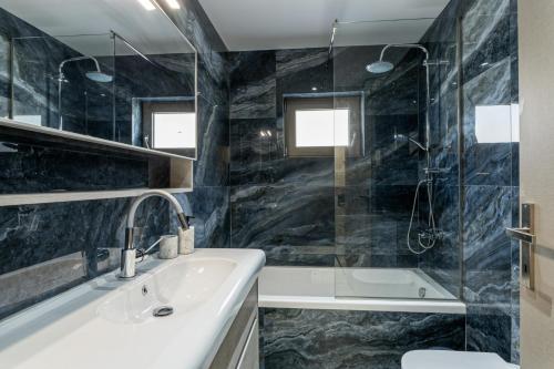 a bathroom with a sink and a tub and a shower at Elysian Villas - With 2 Private Pools in Roumelí