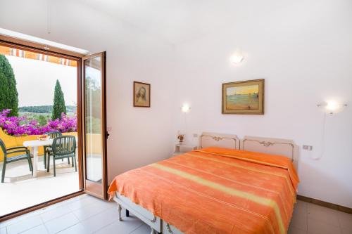 a bedroom with a bed and a table and a balcony at Agriturismo Posta Pastorella in Vieste