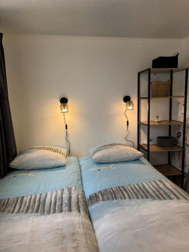 two beds sitting next to each other in a room at Aangenaam Texel Familie Bungalow in De Koog