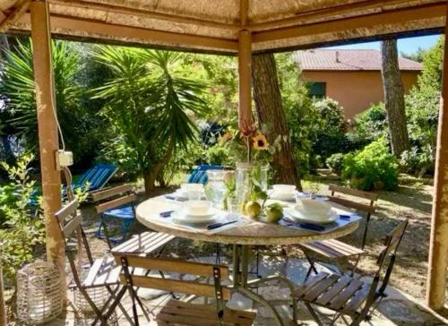 une table et des chaises sous un pavillon sur une terrasse dans l'établissement Casa Nora, à Castiglioncello