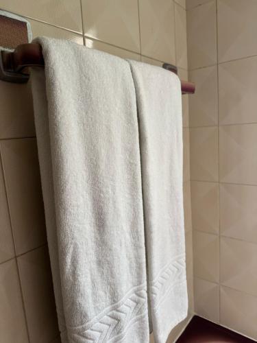 a group of white towels hanging on a rack in a bathroom at House Mariona in Caminha