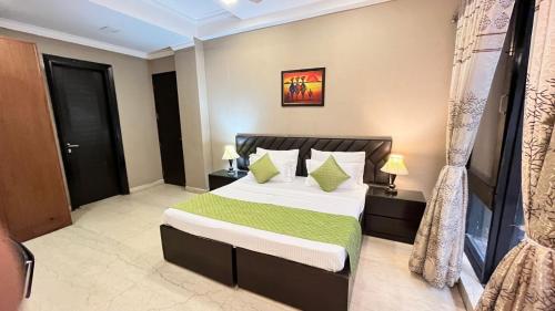 a bedroom with a large bed with a green blanket at Abode Residency near USA Embassy Delhi Safdarjung Enclave New Delhi in New Delhi