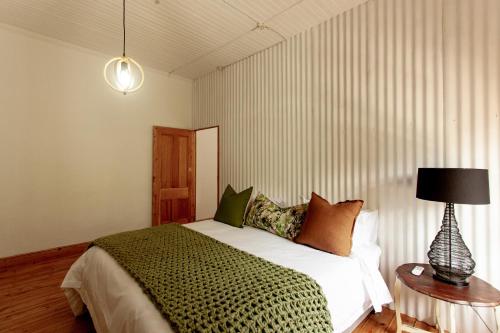 a bedroom with a bed and a lamp on a table at Double Story at 55 in Graaff-Reinet