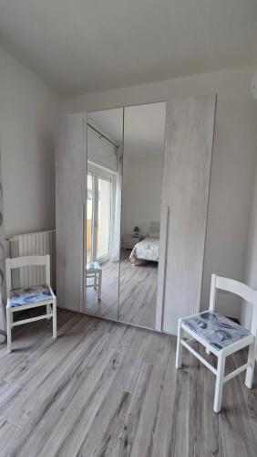 a room with a mirror and a chair and a bed at Stanze Del Mare - Sea Rooms in Otranto