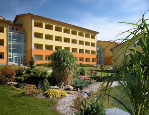 a building with a garden in front of a building at Wellness apartmán Frymburk D403 Čtvrté patro in Frymburk