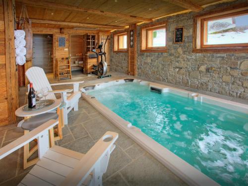 una grande piscina in una casa di legno di La Ferme du Gran Shan - OVO Network a Les Villards-sur-Thônes