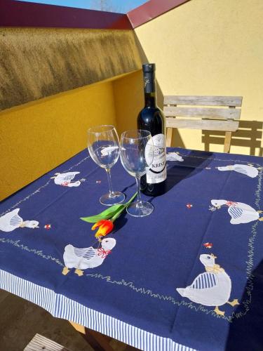 a bottle of wine and two wine glasses on a table at Wellness apartmán Frymburk D403 Čtvrté patro in Frymburk