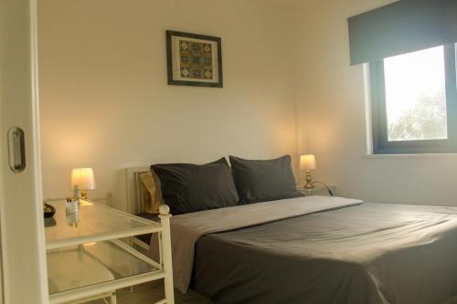 a bedroom with a bed and a glass table at Mediterranean Apartments 1 in Paphos City