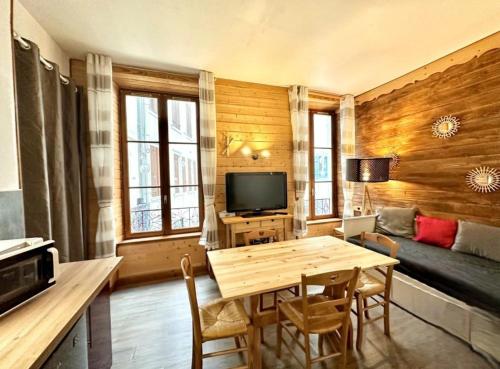 una sala de estar con una mesa y un sofá en Appartement 4 à 6 personnes Hyper Centre au Calme dans impasse AVEC PARKING, en Cauterets