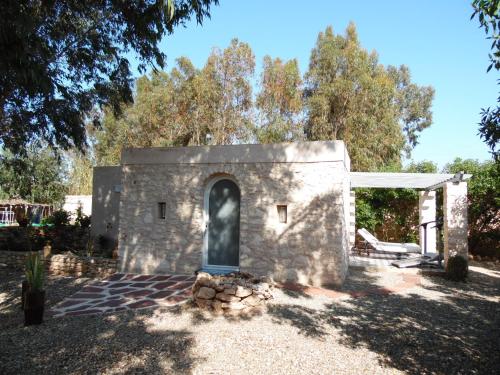 a stone building with a door in a yard at Villa Daba in Ghazoua