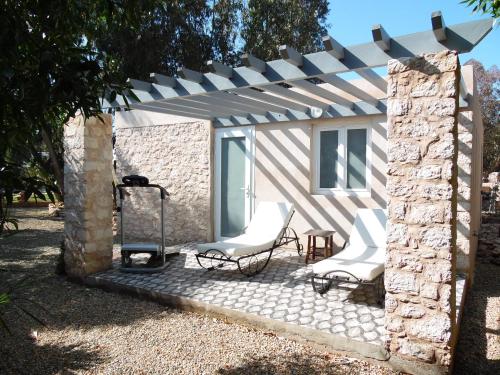 a pergola with two chairs and a table at Villa Daba in Ghazoua