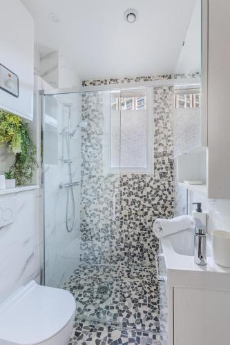 une salle de bain avec une douche avec des toilettes et un lavabo dans l'établissement Orteaux - Cosy studio proche Père Lachaise, à Paris