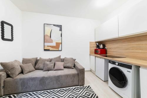 un salon avec un canapé et une cuisine dans l'établissement Appartement cosy hopital bichat - paris 18 - 4P, à Paris