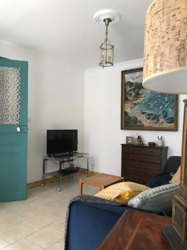 a living room with a blue couch and a tv at Bleu Cottage, escapade proche mer à Ault in Ault