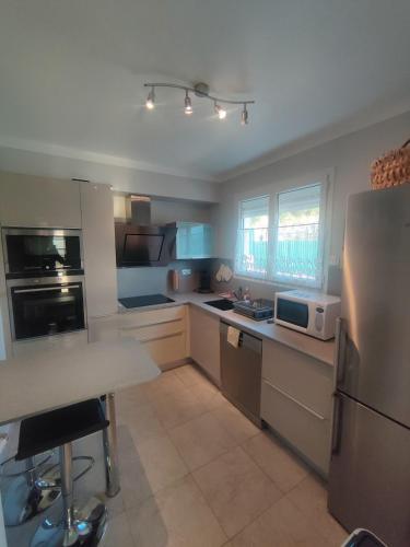 une cuisine avec un réfrigérateur et une table à l'intérieur dans l'établissement Appartement confortable 70m2 au pied du Canigó, à Codalet