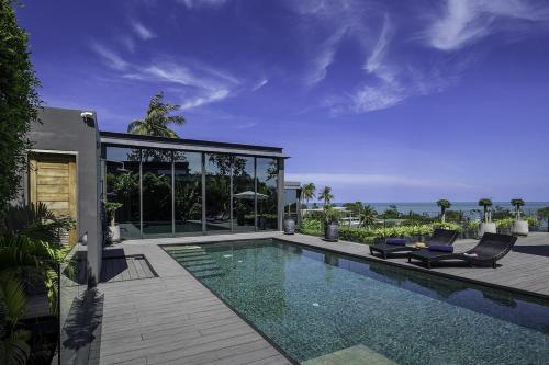 a swimming pool with two chairs and a house at Villa Onyx in Amphoe Koh Samui