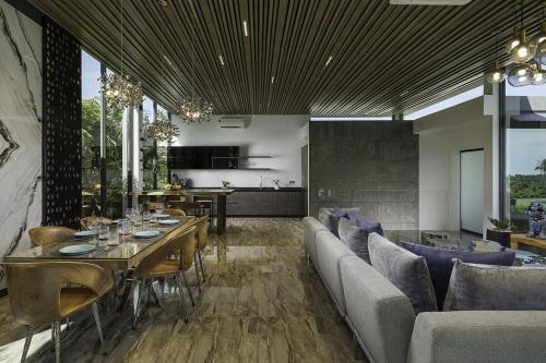 a dining room with a couch and a table at Villa Onyx in Amphoe Koh Samui