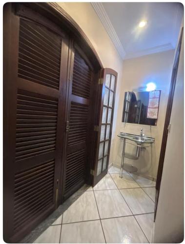 a bathroom with a large wooden door and a sink at Refúgio solar in Socorro
