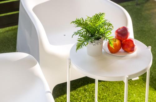 a white chair with a plate of fruit and a plant at TURINHOMETOWN Residence Apartments in Turin