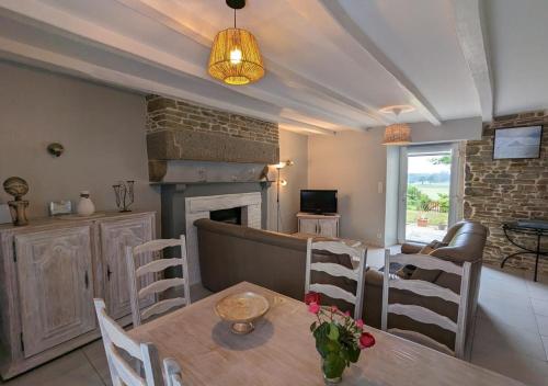 un salon avec une table et une cheminée dans l'établissement GITE PAMPHILIENNE VUE MONT SAINT MICHEL et CAMPAGNE NORMANDE, à Courtils