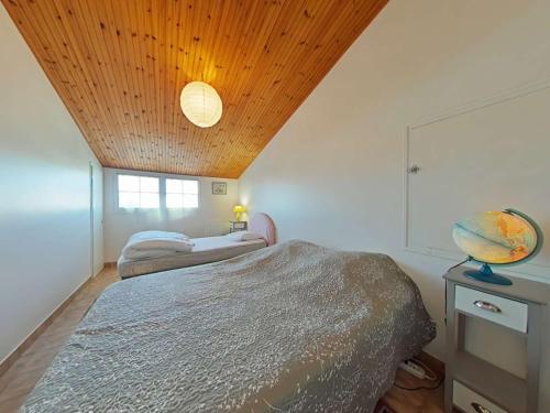 une chambre avec un lit et un plafond en bois dans l'établissement Maison 4 pièces, 7 couchages, proche plage, jardin clos, wifi, calme - Saint-Gilles-Croix-de-Vie - FR-1-224-430, à Saint-Gilles-Croix-de-Vie