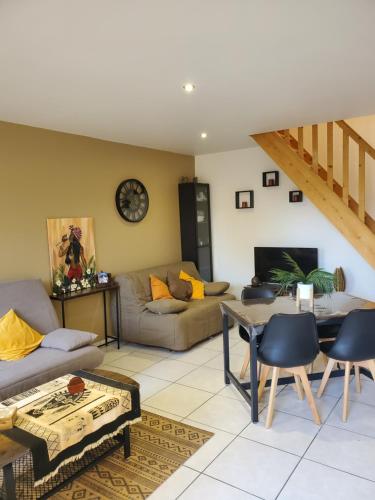 a living room with a couch and a table at LE NAMASTE Charmante maisonnette climatisée de 45 m2 in Brasles