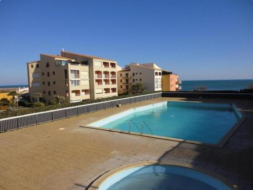 une grande piscine au sommet d'un immeuble dans l'établissement Studio climatisé avec piscine et parking à 20m de la mer - FR-1-607-75, au Cap d'Agde